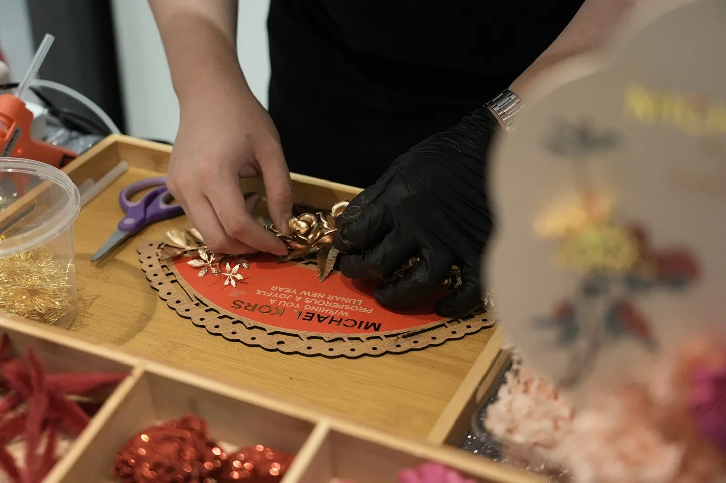 Floral decorations being attached to a Michael Kors seasonal fan.