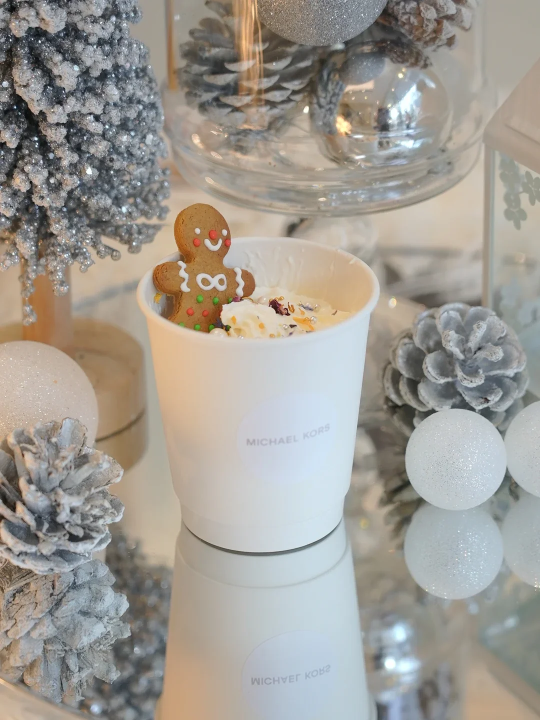 A Michael Kors dessert cup presented with a gingerbread decoration and winter styling.