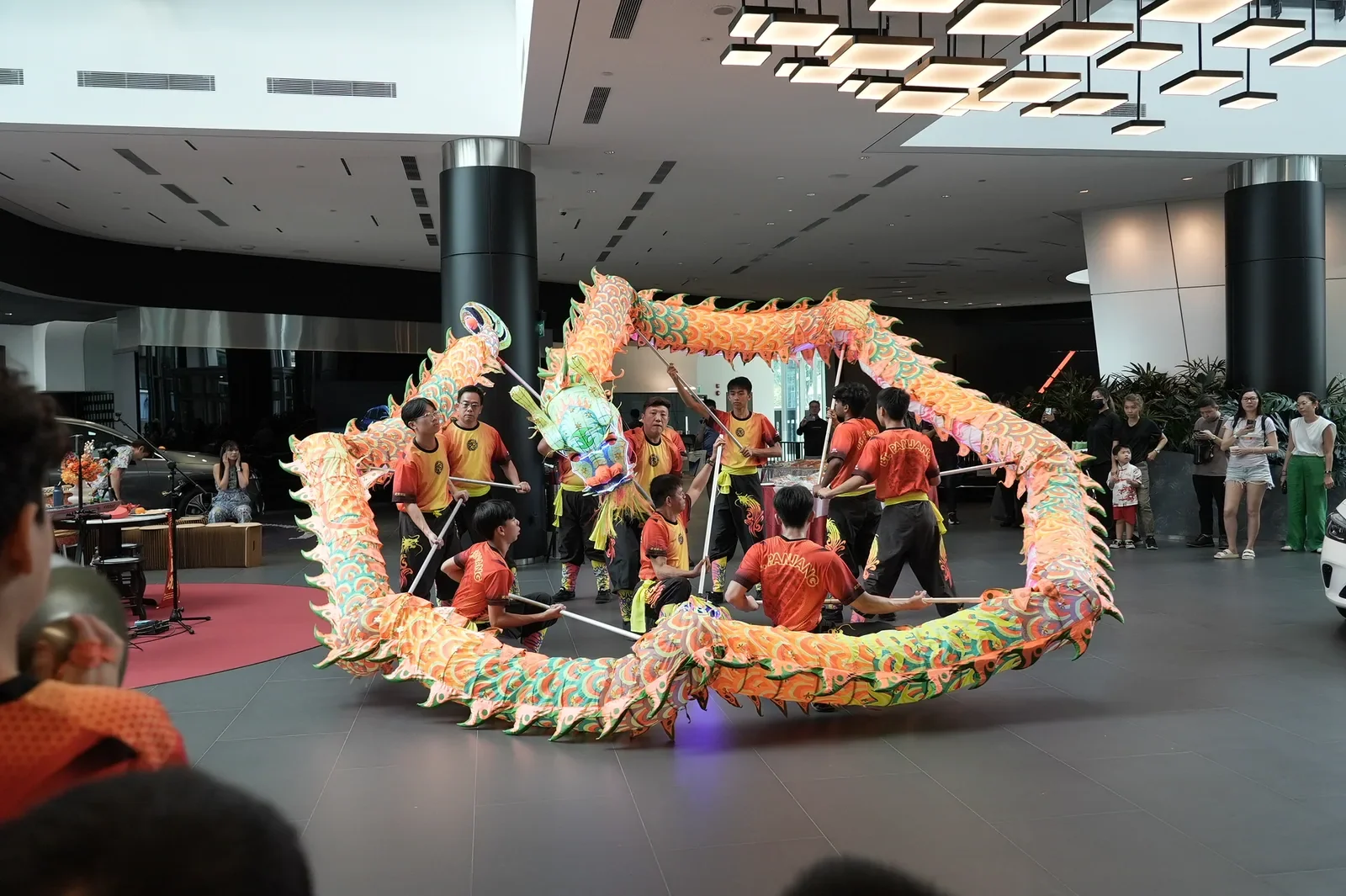 A colourful dragon dance performed by a team in a bright showroom