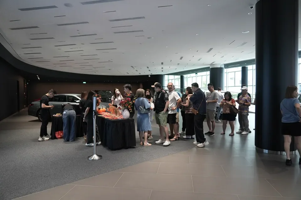 Guests gathering around a staffed live station inside a Mercedes-Benz showroom