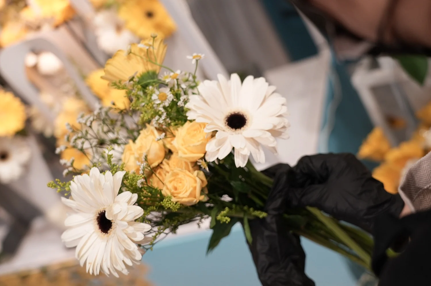 A florist arranging white daisies and yellow blooms at the Michael Kors Bloom Bar