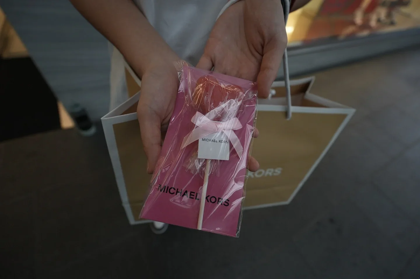 A ribbon-wrapped Michael Kors gift presented in branded packaging.