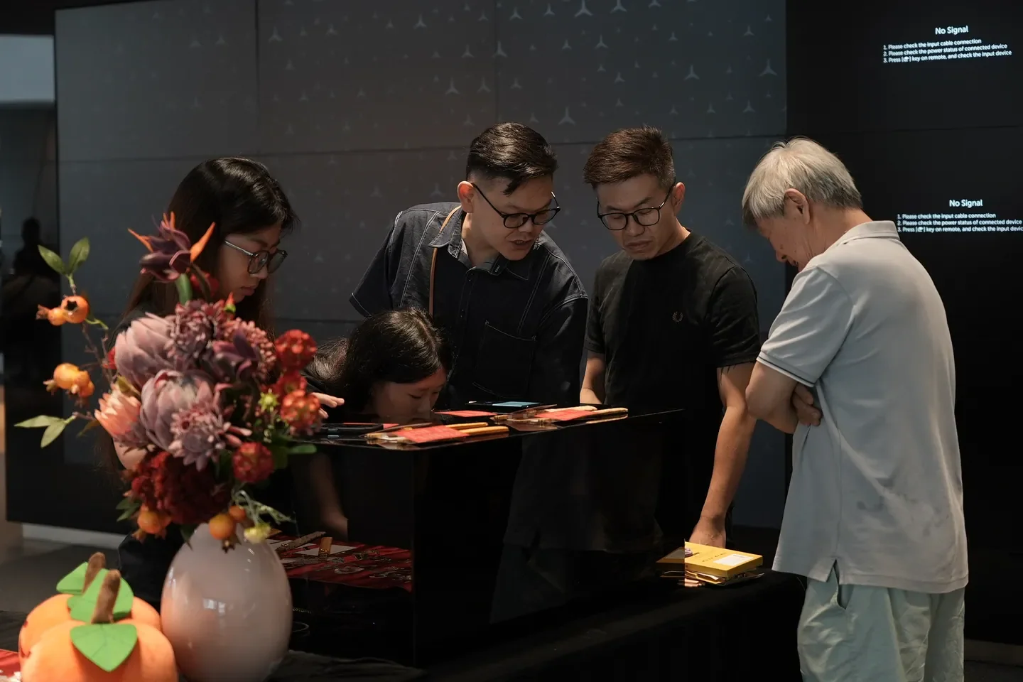 Guests and a staff member at a flower-arranging activity station inside a showroom